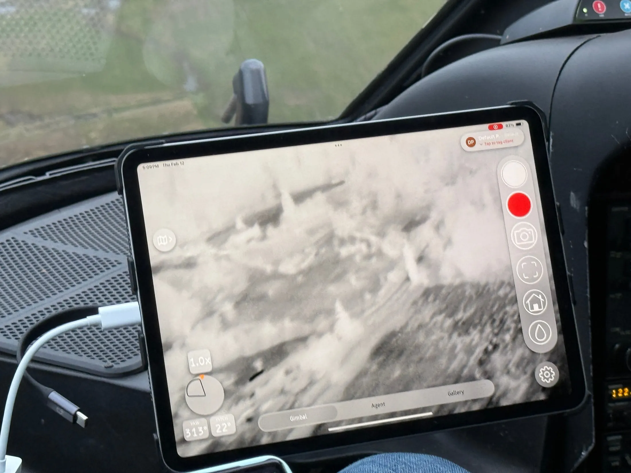 A tablet in the aircraft cockpit displaying a thermal view of the terrain