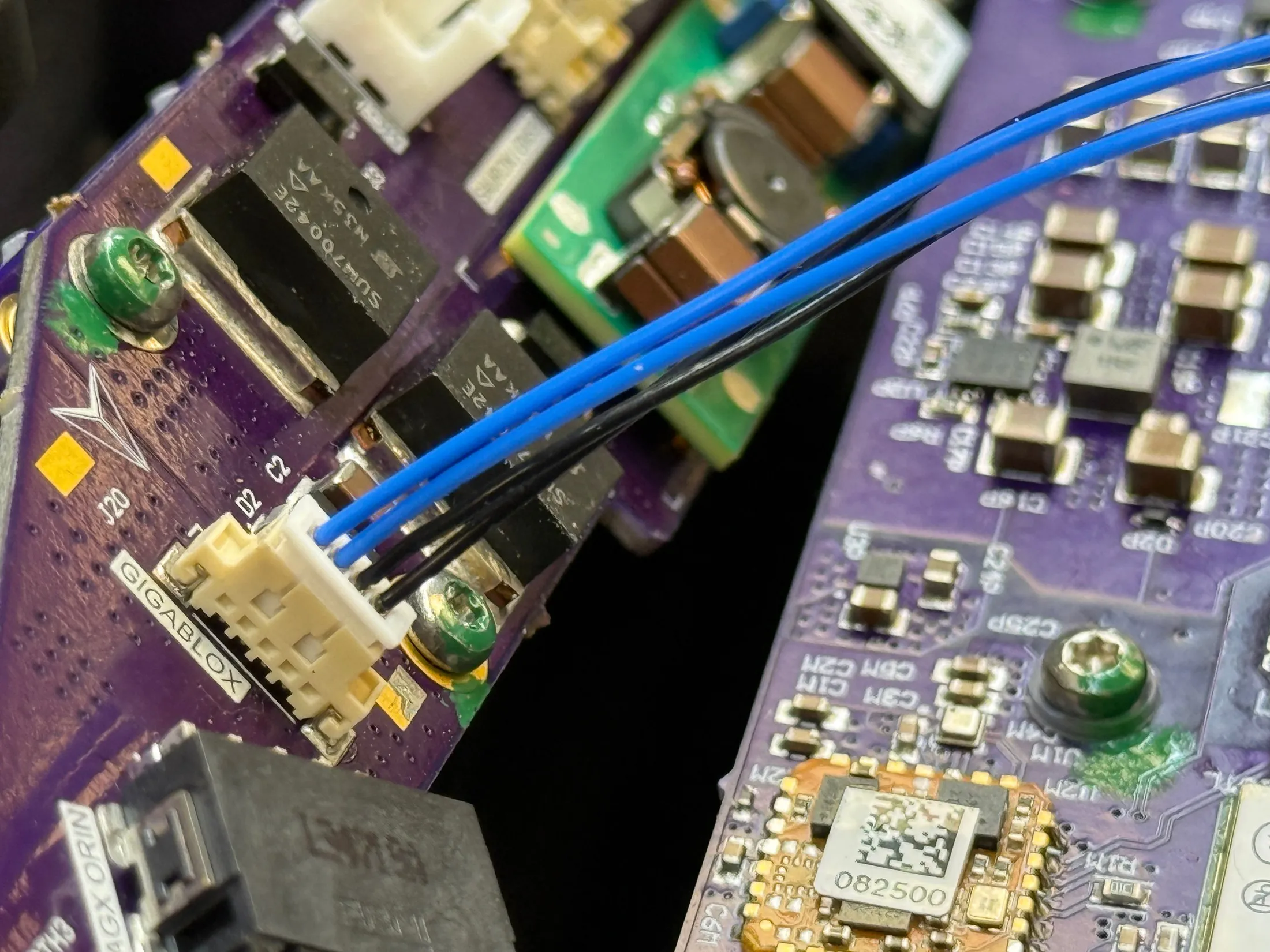 Close-up of purple Voxelis circuit boards with the delta mark, components, and connected wiring